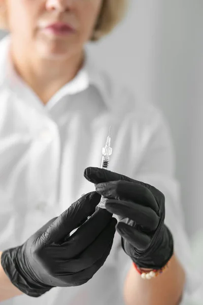メディックガールは手に注射器を持ち 空気を放出する 作業のための準備を取得注射器付き黒手袋の医療従事者 — ストック写真