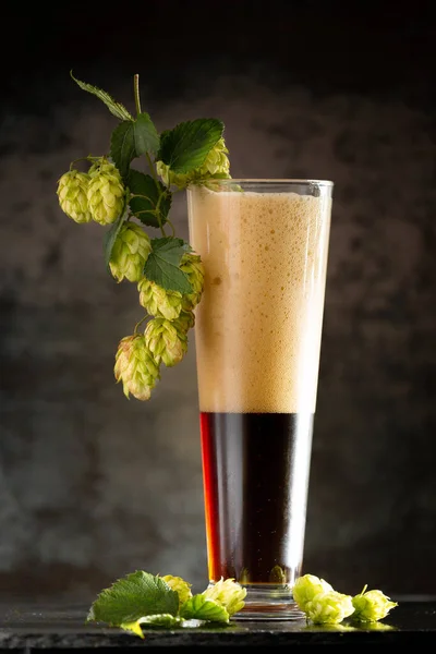 Cerveza Oscura Una Taza Lúpulo Verde Sobre Una Mesa Madera — Foto de Stock