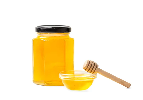 蜂蜜の形をしたガラス瓶の創造的な組成は 白の背景のクローズアップで蜂蜜と異なるサイズを兼ね備えています 別の位置に有機蜂蜜とガラス瓶と隔離上のディッパー — ストック写真