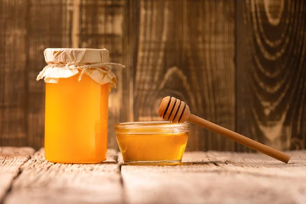 在一个玻璃瓶和一个碗里 在一个古老的木制背景上 有创意的蜂蜜组合 有机蜜蜂产品的概念 — 图库照片