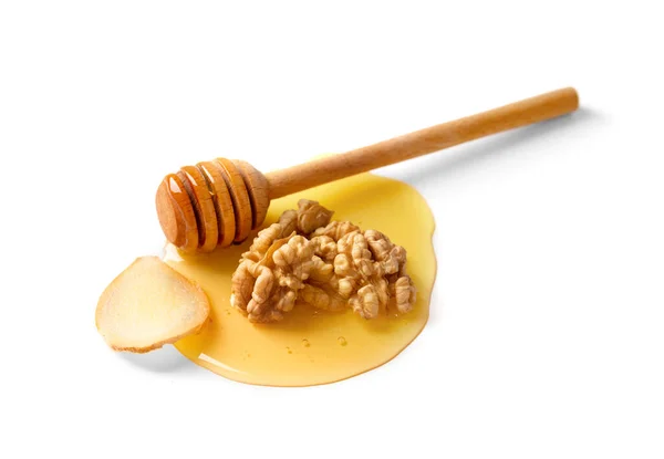 几颗核桃 几片生姜和一个木制的胡桃夹在一滴蜂蜜中 放在白色背景的特写上 白色背景下的大型核桃和蜂蜜 — 图库照片