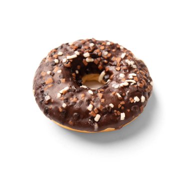 One donut in chocolate glaze sprinkled with pieces of white, milk and dark chocolate isolated on a white background. High-calorie junk food. Sweet snack. Baking for breakfast.