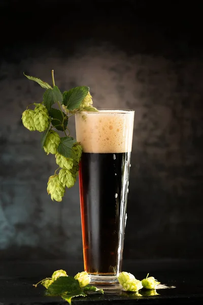 Cerveza Oscura Una Taza Lúpulo Verde Sobre Una Mesa Madera — Foto de Stock