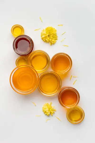 蜂蜜在一个不同大小的玻璃碗在一个白色背景的顶部视图 蜂蜜瓶分离的创造性成分 — 图库照片