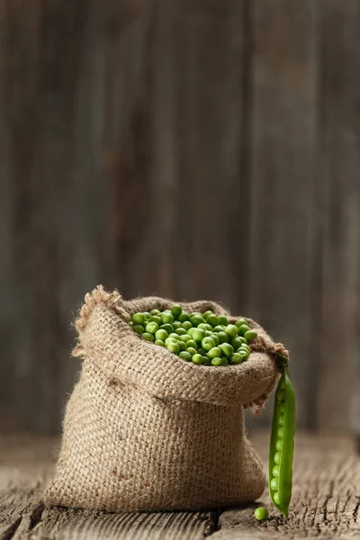 新鲜的有机豌豆皮在背包里 开放的绿色豌豆豆荚在老化的木制背景上 复制空间 植物蛋白 健康产品 — 图库照片