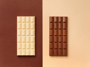 Kahverengi arka planda beyaz çikolata, açık arkaplanda koyu çikolata, üst tarafta üst arkaplanda çikolata, metin için boşluk.
