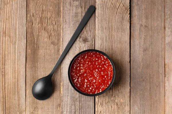 Roter Lachskaviar Einer Offenen Schwarzen Blechdose Und Ein Schwarzer Löffel — Stockfoto