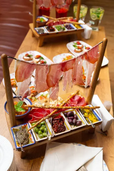 原汁原味的肉类小吃 在餐馆的桌子上摆的是反派 意大利的开胃菜是配酒的 免版税图库照片