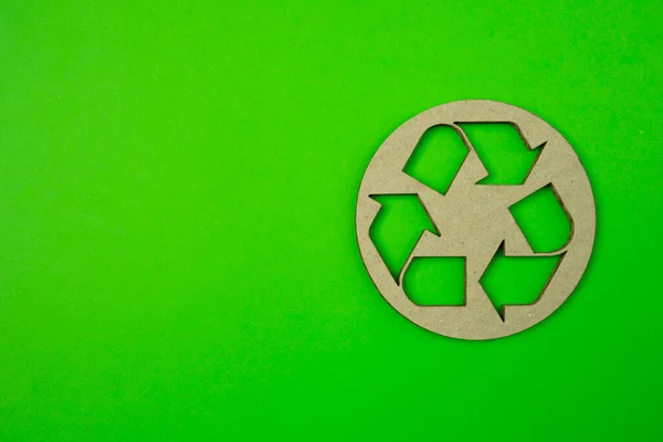 Paper cut of recycle logo on green background with free copyspace for your creativity ideas text.