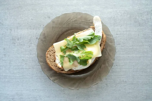 烤鸡蛋 面包上有奶酪和香草 早餐放在盘子和烧烤板上 — 图库照片