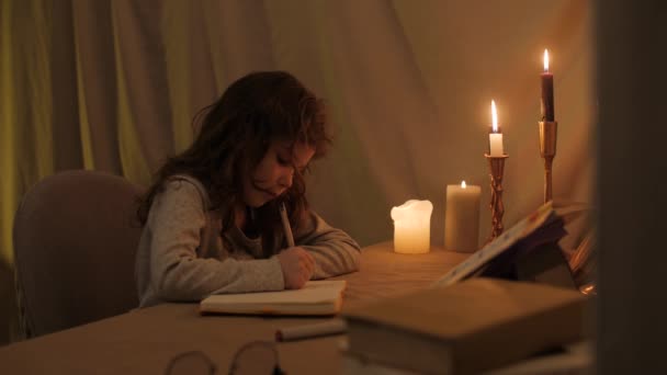 Κοπέλα Κάνει Την Εργασία Της Ένα Σκοτεινό Διαμέρισμα Κεριά Αντιγράφει — Αρχείο Βίντεο