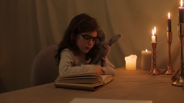 Dziewczyna Trzyma Swojego Przyjaciela Zabawkę Zając Rękach Czyta Książkę Okularach — Wideo stockowe
