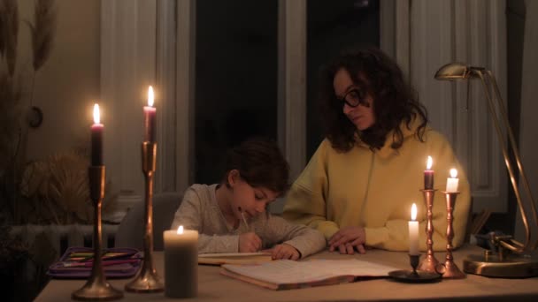 Kıvırcık Saçlı Süveter Gözlüklü Anne Mum Işığında Kızının Ödevlerine Yardım — Stok video
