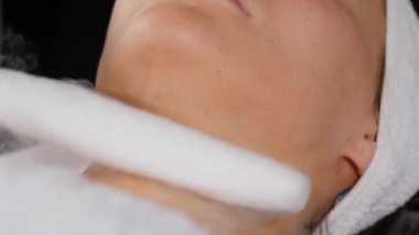Güzellik uzmanı sıvı nitrojen buharı kullanan bir kadına işlem uygular..