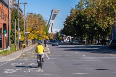 Montreal, CA - 10 Ekim 2022: Sonbaharda Rachel caddesinde bisiklet süren adam