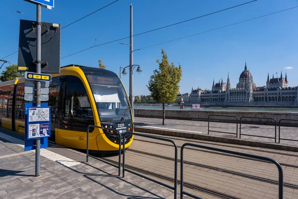 stock image Budapest, Hungary - 3 September 2022: A yellow streetcar in downtown Budapest, with Hungarian parliament in background