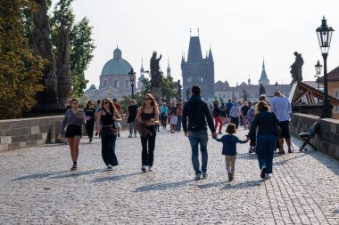 Prag, Çek Cumhuriyeti - 5 Eylül 2022: Charles Köprüsü üzerinde yürüyen insanlar, arka planda Eski Köprü kulesi