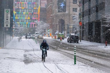 Montreal, CA - 16 Kasım 2022. Montreal 'de kar fırtınası sırasında bisiklet süren bir adam.