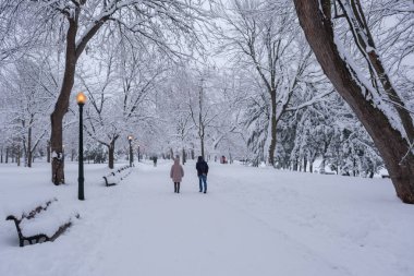 Montreal, CA - 17 Aralık 2022: Lafontaine Park 'ta kar fırtınası sırasında yürüyen yayalar