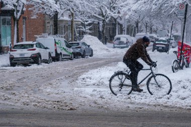Montreal, CA, 17 Aralık 2022: Kar fırtınası sırasında bisiklete binen adam