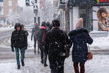 Montreal, CA - 17 Aralık 2022: Kar fırtınası sırasında Mont-Royal Caddesi 'nde yürüyen yayalar
