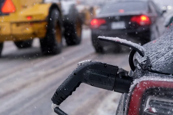 吹雪の中で電気自動車がモントリオールで充電される — ストック写真