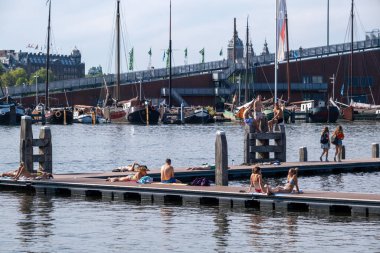 Amsterdam, Hollanda - 6 Eylül 2022: Marineterrein 'in iç limanında yıkanan insanlar