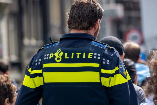 stock image Amsterdam, The Netherlands - 8 September 2022: Backview of a dutch policeman on the street