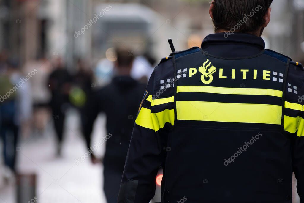 Amsterdam, The Netherlands - 8 September 2022: Backview of a dutch policeman on the street