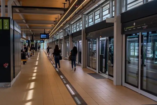 Brossard, CA - 5 Ekim 2023: Panama istasyonunda Reseau Ekspres Metropolitain (REM) treni bekleyen insanlar