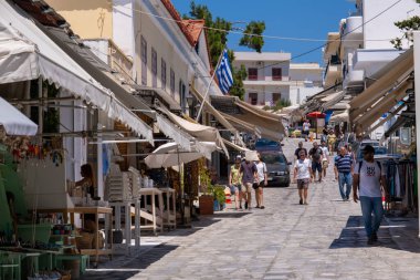 Tinos, GR - 4 Ağustos 2023: Tinos ana caddesinde yürüyen insanlar