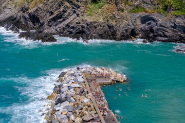 Vernazza, IT - 26 Temmuz 2023: İnsanlar Vernazza iskelesinde güneşleniyor