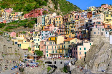 Manarola, IT - 26 Temmuz 2023: Manarola köyünde altın saat boyunca renkli evler