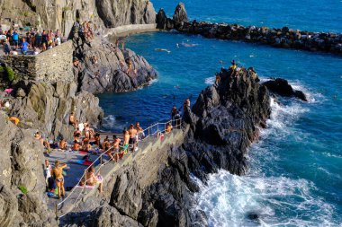 Manarola, IT - 26 Temmuz 2023: Manarola Limanı 'nda güneşlenen insanlar