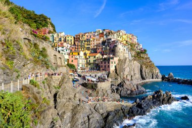 Manarola, IT - 26 Temmuz 2023: Manarola köyünde altın saat boyunca renkli evler