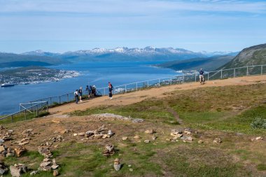 Tromso, Norveç - 16 Temmuz 2023: Storsteinen Dağı 'nın tepesinden Tromso' ya bakan turistler