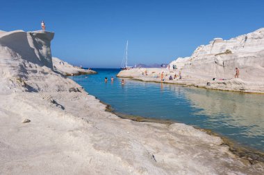 Milos, GR - 28 Eylül 2024: Sarakiniko plajında güneşlenen insanlar