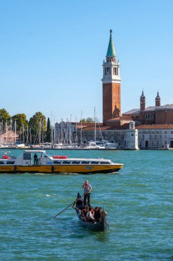 Venedik, İtalya - 12 Ekim 2024: Gondol ve motorbotlar San Giorgio Maggiore yakınlarındaki Venedik lagününden geçiyor
