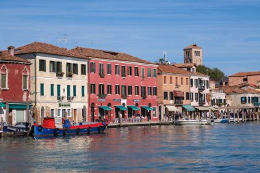 Venice, Italy - 12 October 2024: A row of colorful waterfront buildings in Murano clipart