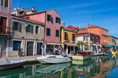 Venedik, İtalya - 12 Ekim 2024: Camcılık geleneğiyle ünlü tarihi Venedik adası Murano 'nun kanal sularına yansıyan renkli evler dizisi.