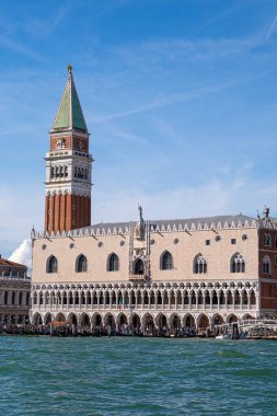 Venedik, İtalya - 12 Ekim 2024: St Marks Campanile ve Basilica di San Marco 'nun kubbeleri açık mavi gökyüzü altında Venedik rıhtımının üzerinde yükseliyor