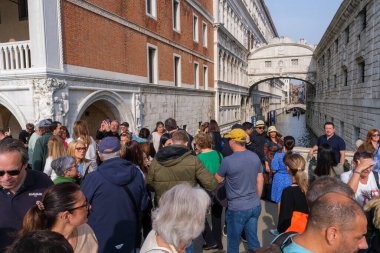 Venedik, İtalya - 12 Ekim 2024: Turistler İç Çekmeler Köprüsü 'ne bakan bir köprüde toplanarak, Venedik' te aşırı turizmin etkisini gözler önüne serdiler.