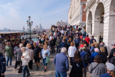 Venedik, İtalya - 12 Ekim 2024: Şehrin en çok ziyaret edilen bölgelerinden birinde aşırı turizmin etkisini gösteren yoğun turist akışının yer aldığı Doge 's Palace yakınlarında kalabalık bir manzara