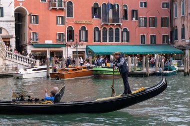Venedik, İtalya - 12 Ekim 2024: İnsanlar Campo de l 'Arsenal' de açık bir kafede arka planda mermer bir aslan heykeli ile yemek yiyor