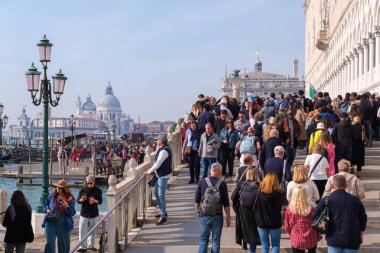 Venedik, İtalya - 12 Ekim 2024: Şehrin en çok ziyaret edilen bölgelerinden birinde aşırı turizmin etkisini gösteren yoğun turist akışının yer aldığı Doge 's Palace yakınlarında kalabalık bir manzara