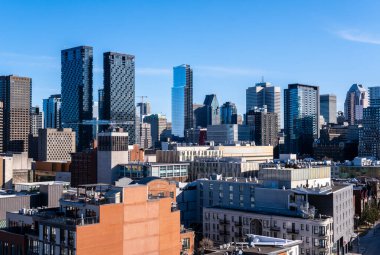 Montreal, Kanada - 4 Nisan 2025: Montreal 'in çeşitli gökdelenlerinin geniş bir görüntüsü, tarihi çatıları modern gökdelenlerle birleştirerek berrak bir yay gökyüzü altında