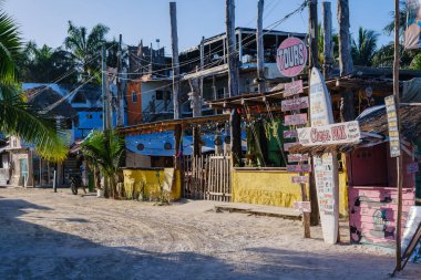 Holbox Adası, Meksika - 12 Şubat 2025 Holbox Adası 'nda kumlu yollar, renkli binalar ve kırsal bir turne tabelasının yer aldığı güneşli bir sokak manzarası..