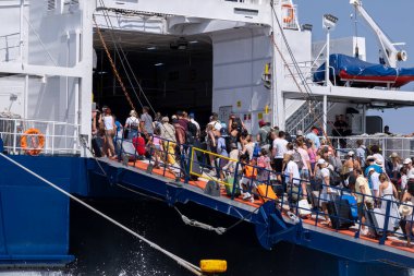 Parikia, Paros, GR - 22 Ağustos 2025: İnsanlar arka rampadan feribota biniyor