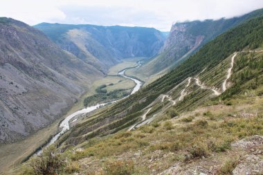 Katu-Yaryk 'tan Chulyshman Vadisi' ne geçiş. Yüksek dağlar tehlikeli bir yol, aşağıdaki bir nehir. Altai, Sibirya, Rusya. Yaz mevsimi Altai dağlarında. 