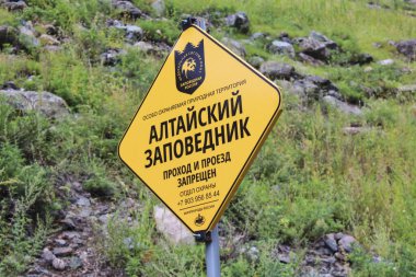 Rusça sarı tabeladaki yazı, özel korumalı bölge. Altai Rezervi. Geçiş ve geçiş yasaktır..